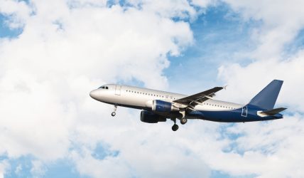 airplane-flying-cloudy-sky-scaled.jpg